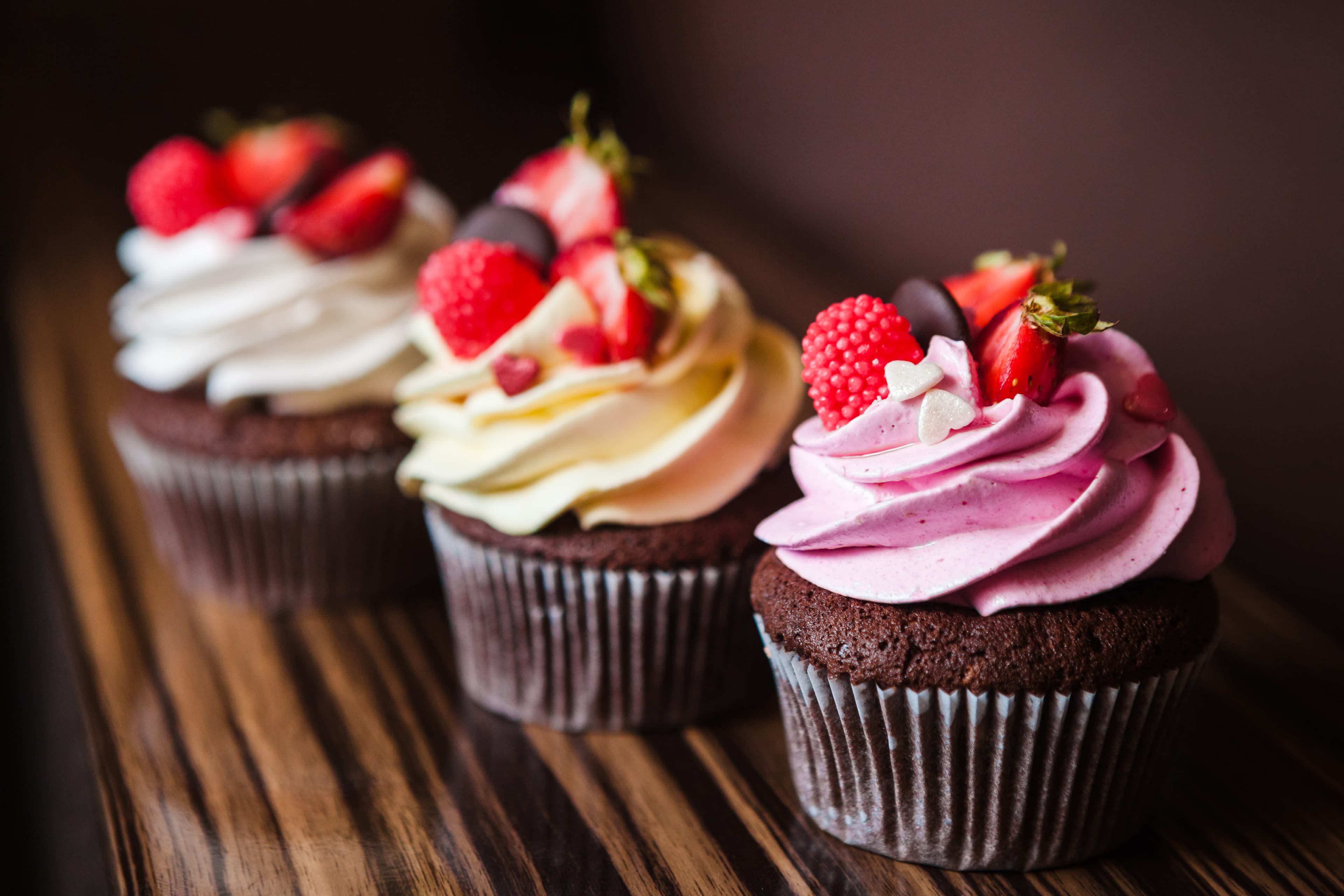 Chocolate cupcakes with fruit and cream on top